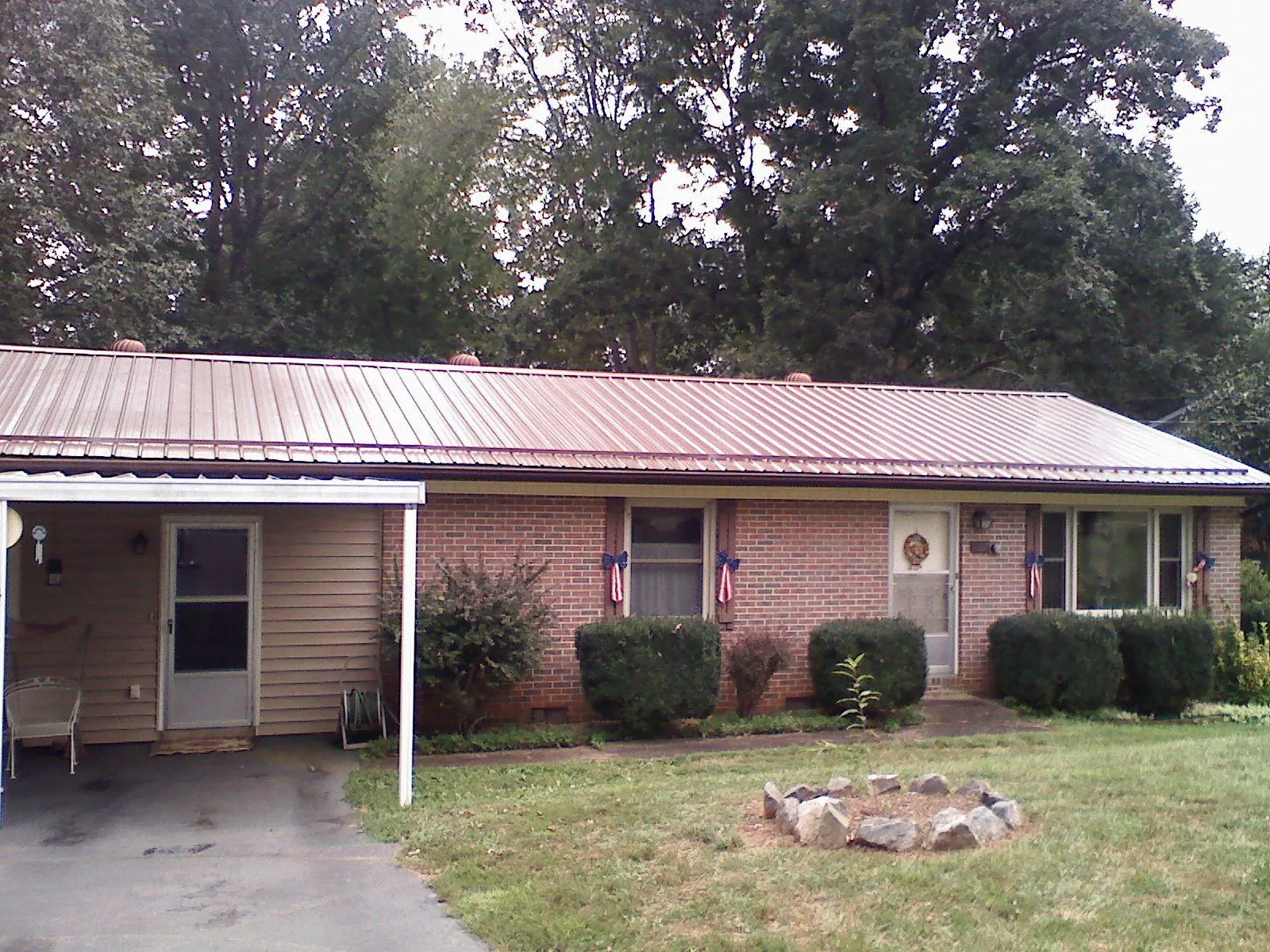Bronze metal roof and carport on a brick ranch home — Roof Repair work by our crew in Jefferson